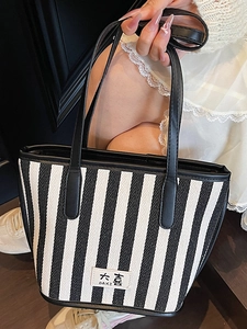 Minimalist striped canvas tote bag with black leather handles and casual chic design