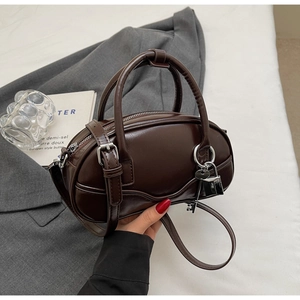 Close-up of chocolate brown patent leather bowling bag with silver lock and key charm
