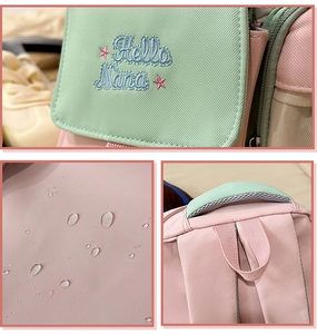 Macro detail of waterproof fabric and embroidery on pastel pink and green backpack