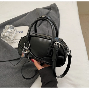 Detail of black patent leather bowling bag with silver hardware and chic padlock charm