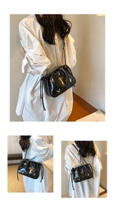 Détails du sac à main noir brillant à motif crocodile avec des papillons métalliques argent
