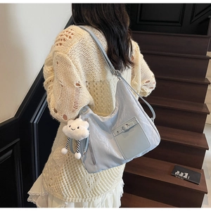 Detail of light blue pleated tote bag with cloud charm pendant and front buckled pocket