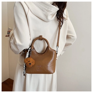 Damen Handtasche in Karamellbraun mit Teddy-Anhänger und gemustertem Seidenschal