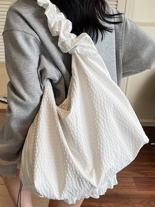 White bubble texture tote bag with ruffled shoulder strap shown on a model in home setting