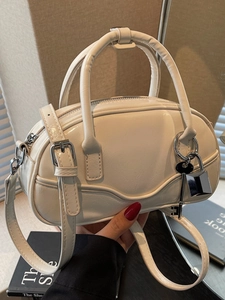 Chic cream bowling handbag with silver lock charm and adjustable crossbody strap