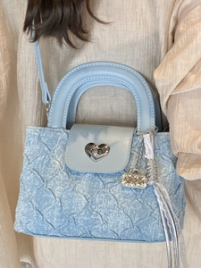 Light blue quilted handbag with silver heart lock and lace ribbon detail on strap