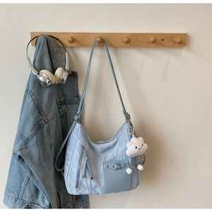 Detail of light blue tote bag showing crinkle fabric texture and cloud plush charm