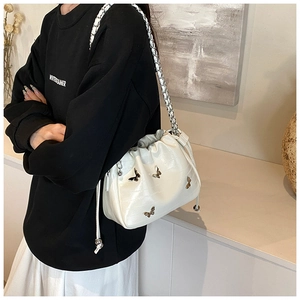 Détail du sac nuage blanc avec accents de papillons argentés et fermeture à cordon coulissant