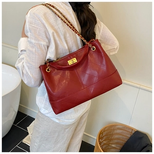 Detail showing red oil wax leather handbag with diamond quilting and gold chain strap