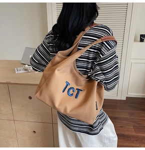 Détail du sac cabas en toile marron avec broderie TCT bleue et bandoulière en cuir souple
