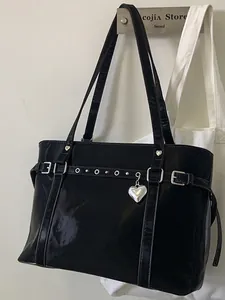 Fashionable black patent leather bucket bag with silver heart pendant and metal rivets