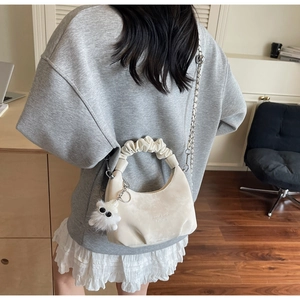 Detail of cream cloud bag with ruched handle, silver chain and cute plush monster charm