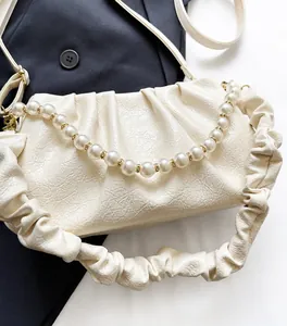 Detaillierte Nahaufnahme der cremefarbenen Wolken-Tasche mit Perlengriff und weichem PU