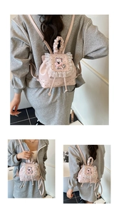 Detail view of pink polka dot backpack featuring white lace trim and cute bear embroidery