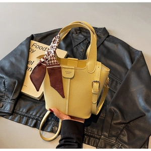Detail of yellow lychee leather bucket bag with dogtooth silk scarf and thin strap