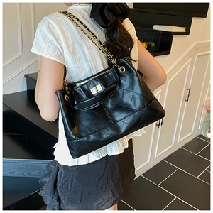 Close-up of the black quilted tote bag with golden metal chain strap and turn-lock closure