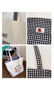 Detail view of canvas tote bag featuring embroidered rabbit art and plaid lining accents