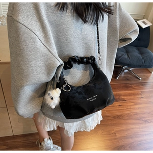 Detail of black cloud pleated hobo bag with white sheep charm and silver chain strap