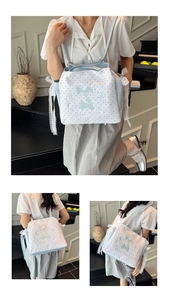 Détail du sac cabas en toile bleu clair avec dentelle, broderie lapin et pois