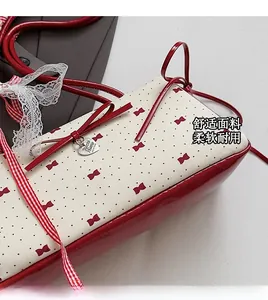 Detail of red polka dot bag with heart pendant and decorative ribbon bow texture