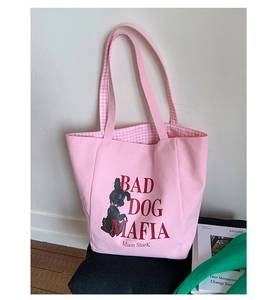 Close-up of pink canvas tote bag showing poodle illustration and red letter embroidery