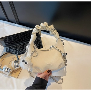 Detail of off-white ruched hobo bag with silver chain, plush ball and bear pendant charm