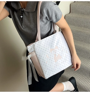 Detailed rabbit embroidery and pink lace bow on a white polka dot tote shoulder bag