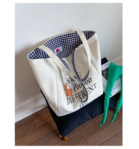 Detail of canvas tote bag showing orange rabbit print and interior checkered lining