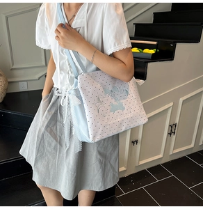 Detail of light blue polka dot canvas tote with bow embroidery and lace edges