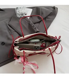 Spacious interior of white polka dot handbag with bow showing everyday essentials and pocket