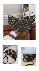 Detailed view of dark grey suede crescent bag featuring golden rivets and metallic eyelets