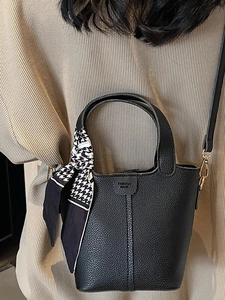 Classic black leather bucket bag with houndstooth silk scarf and gold hardware accents