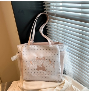 Détail du sac en toile à pois avec bordure en dentelle et broderie de lapin rose mignonne
