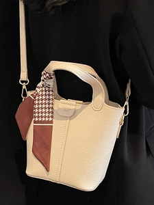 Classic cream bucket bag with lychee texture and houndstooth scarf on black coat