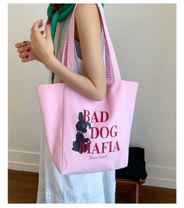 Detail of pink canvas tote bag featuring poodle illustration and plaid lining on shoulder strap