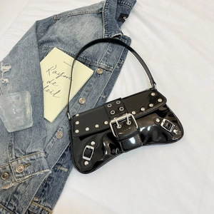 Detail shot of black patent leather underarm bag with silver rivets and metal buckle design