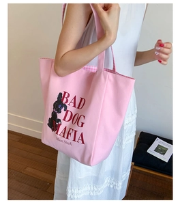 Detail of pink canvas tote bag showing the cartoon dog print and spacious interior