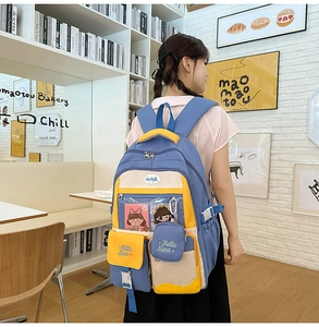 Detailed view of blue and yellow nylon backpack with multiple pockets and Hello Nana embroidery