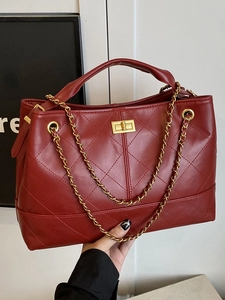 Elegant red quilted tote bag with golden metal clasp and chain shoulder strap