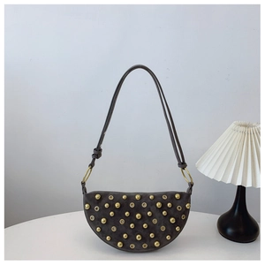 Detail of dark grey suede crescent bag with golden metallic rivets and eyelets