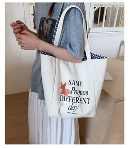 Detail view of white canvas tote bag featuring dog print and gingham inner lining pattern