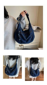 Detailed view of dark blue denim tote bag featuring multi-zipper pockets and wide strap