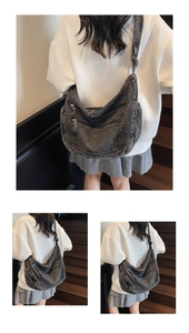 Detail of grey washed denim crescent crossbody bag with three zipper pockets