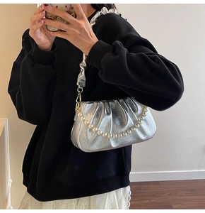 Silberne Metallic-Wolktasche mit Perlenkette und plissierter Textur auf der Oberfläche