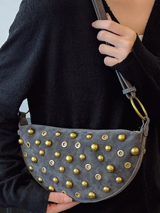 Grey crescent rivet shoulder bag with gold metal eyelets and punk style aesthetic