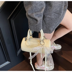 Detail of cream barrel bag with sheer mesh bow, pearl charm and FASHION & BAG text