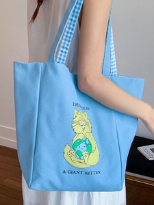 Light blue canvas tote bag with yellow cartoon cat print and blue gingham straps