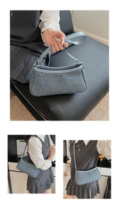 Dettaglio della borsa sottobraccio in denim azzurro con rivetti argento e tracolla sottile