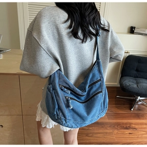 Detail view showing large capacity denim crossbody bag with multiple zip pockets and retro style