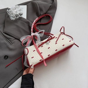 Detail of red and white polka dot bag with lace bow, heart pendant and leather finish